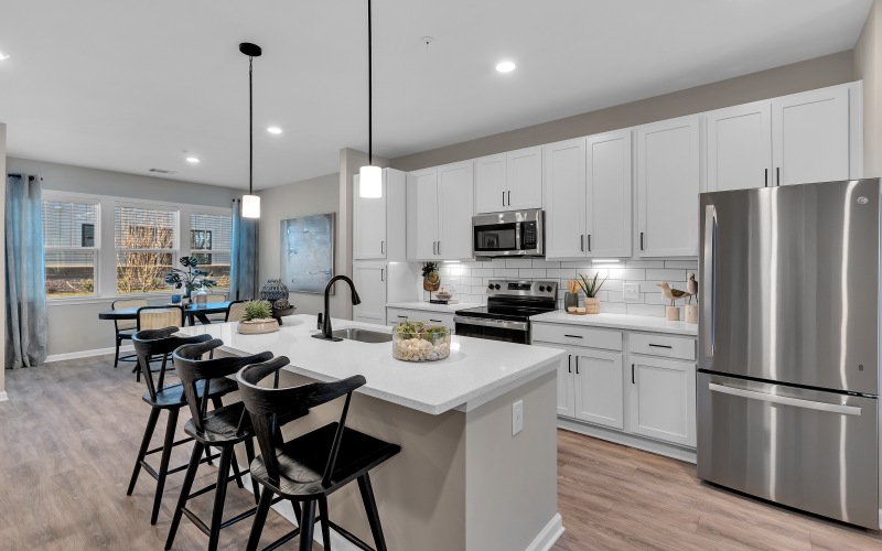  A modern kitchen with a large island and stainless steel appliances.