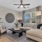  A living room with a beige couch, a wooden chair, a coffee table, and a ceiling fan.